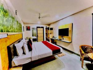 a bedroom with a bed and a desk and a television at Hotel Lake View Airport zone in Hyderabad