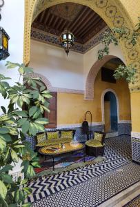 einen Innenhof mit einem Tisch und Stühlen in einem Gebäude in der Unterkunft Palais didi in Meknès