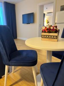a living room with a table and a blue chair at Batumi Orbi City Lux Apartment 5* in Batumi +12 photos
