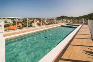 a swimming pool on the roof of a building at Lindos Studios VEC in Bombinhas