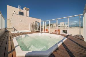 a hot tub on the deck of a building at Lindos Studios VEC in Bombinhas