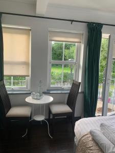 1 dormitorio con mesa, 2 sillas y 1 cama en Isserkelly House en Clonbur