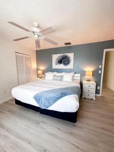 a bedroom with a large bed and a ceiling fan at Sebastian Saltwater Lodge in Sebastian