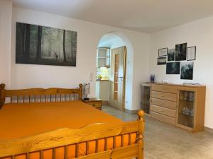 1 dormitorio con cama de madera y vestidor en Ferienwohnung Buchberg, en Neuenbürg