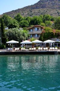 a dock with chairs and umbrellas on the water at Melisa Hotel in Bozburun