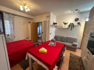 a living room with a red table and a couch at monolocale in centro in Asiago