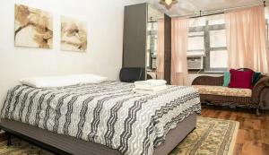 a bedroom with a bed and a chair and a window at Marvelous 3BR in NYC! in New York