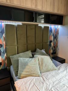 1 cama con cabecero acolchado y almohadas en Mieszkanie w Pruszkowie, en Pruszków