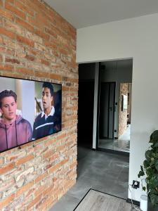 ceglana ściana z dwoma telewizorami w obiekcie Mieszkanie w Pruszkowie w Pruszkowie