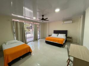 a hotel room with two beds and a window at Alka's Paradise Guest House and Lodging in San Andrés