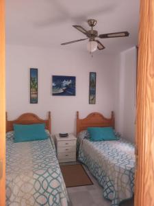 um quarto com 2 camas e uma ventoinha de tecto em Casa Gran Tropicana playa a 2 minutos. em Almuñécar