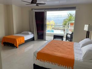 a bedroom with two beds and a balcony with a view at Alka's Paradise Guest House and Lodging in San Andrés