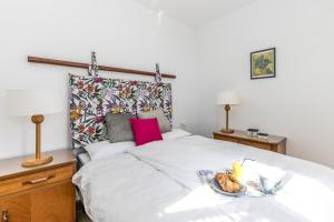 a bedroom with a bed with a plate of food on it at EDEN RENTALS Seaside Getaway in Puerto de Santiago +23 photos