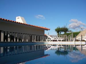 a swimming pool with chairs and a house at Villa São Paulo in Funchal