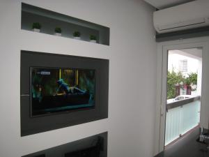 a living room with a tv on a wall at Cascais FEELINGS in Cascais