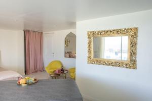 Habitación con cama y espejo en la pared. en LES SUITES LOVE 2 SPA VUE MER PISCINe, en Marsella