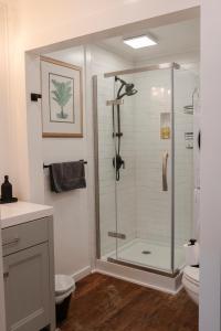 a bathroom with a shower with a glass door at 1885 Garden Studio - Historic Heart of Savannah - Pulaski Ward in Savannah