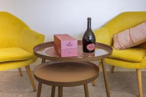 - une bouteille de vin sur une table à côté de deux chaises dans l'établissement LES SUITES LOVE 2 SPA VUE MER PISCINe, à Marseille