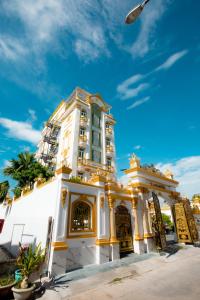 a white building with gold trim on a street at KING VILLA QUẢNG NGÃI in Quang Ngai