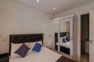 - une chambre avec un lit doté d'oreillers bleus et d'un miroir dans l'établissement 360 Summit Pinheiros, à São Paulo