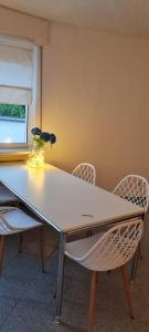 una mesa con dos sillas y un jarrón con flores. en Mobiliertes Appartement, en Bad Homburg vor der Höhe
