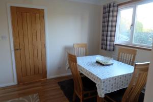 uma sala de jantar com uma mesa e cadeiras e uma janela em Isla Cottage em Blairgowrie
