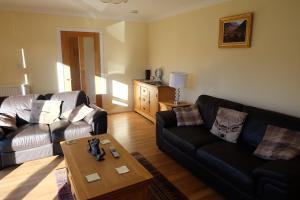 uma sala de estar com um sofá e uma mesa de centro em Isla Cottage em Blairgowrie