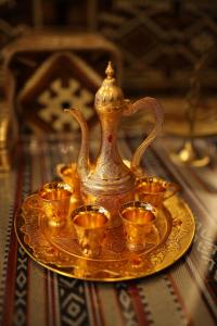 a gold tea set on a gold plate with cups at THE K HOTEL in Dubai