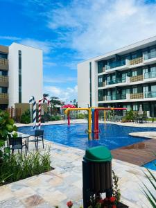 a pool with a playground in front of a building at Mana Beach Resort Muro Alto - vista piscina fantastico -e Makia beach in Porto De Galinhas