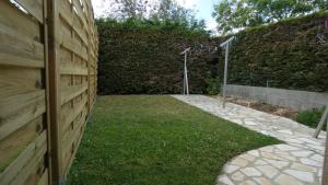 a garden with a wooden fence and a walkway at Chez pat in Ancenis