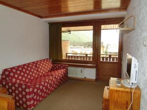 a living room with a red couch and a television at Bilocali Alberti - Rainalter in Madonna di Campiglio