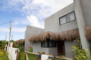 een huis met een rieten dak bij Casa Milagres 03 suítes - 300m da Praia, 6 pessoas in Pôrto de Pedras