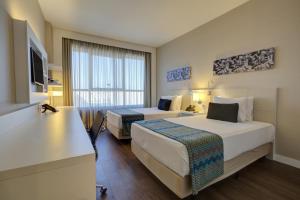 a hotel room with two beds and a television at Quality Hotel São Caetano in São Caetano do Sul