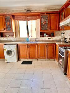 開羅的住宿－A lovely large master bedroom Maadi Degla，厨房配有木制橱柜和洗衣机。