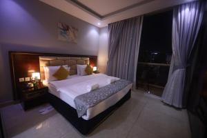 a bedroom with a large bed and a large window at THE K HOTEL in Dubai