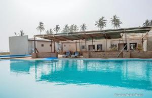 a swimming pool with blue water in front of a building at Breezes Beach Resort 