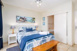 a bedroom with a bed with a blue and white bedspread at Laguna La Crete 44 in Uvongo Beach +16 photos