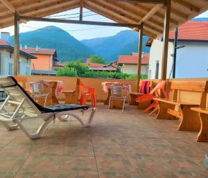 un patio con sillas, una mesa y un banco en ViBo Guesthouse, en Sapareva Banya