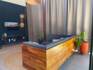 a living room with a couch and a tv at Chalé Litoral Norte - em condomínio de praia in Camaçari
