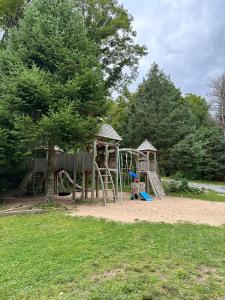 a playground with a slide and a play structure at The Pines Cottage On The Lake in Otter Lake