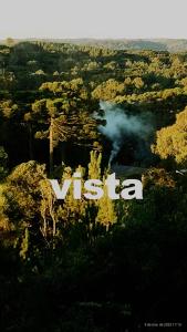 a sign that says vtec in the middle of a forest at Suites nas Nuvens Premium in Gramado
