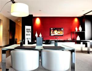 パドヴァにあるAC ホテル パドヴァ ア マリオット ライフスタイル ホテルの赤い壁のダイニングルーム(テーブル、椅子付)