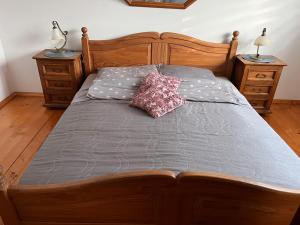 1 cama con marco de madera y almohada en Dom w górach, en Koszarawa