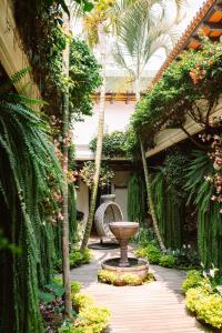 a garden with a fountain in the middle of a courtyard at Los Olivos Boutique Hotel Antigua Guatemala in Antigua Guatemala