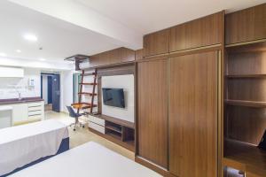 a bedroom with a bed and a desk and a kitchen at 1115 Flat Triplo Garvey - Arena BRB in Brasilia