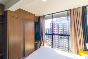 a bedroom with a bed and a large window at 1115 Flat Triplo Garvey - Arena BRB in Brasilia