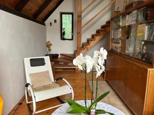 ein Wohnzimmer mit einem weißen Stuhl und einem Tisch in der Unterkunft U Suchánků in Jetřichovice