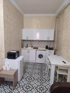a small kitchen with white cabinets and a table at Old City Pansiyon in Istanbul