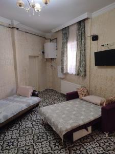 Cette chambre comprend deux lits, un canapé et une télévision. dans l'établissement Old City Pansiyon, à Istanbul