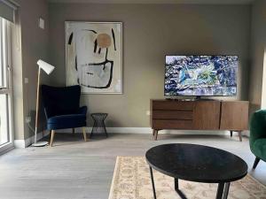 uma sala de estar com uma televisão e uma cadeira azul em 3 bed rooms Vip family house em Dublin